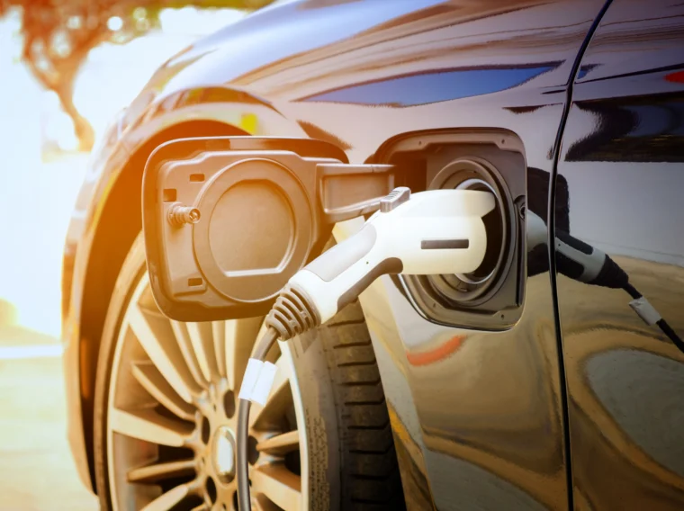 Close up of power supply plugged into an electric car being charged.
